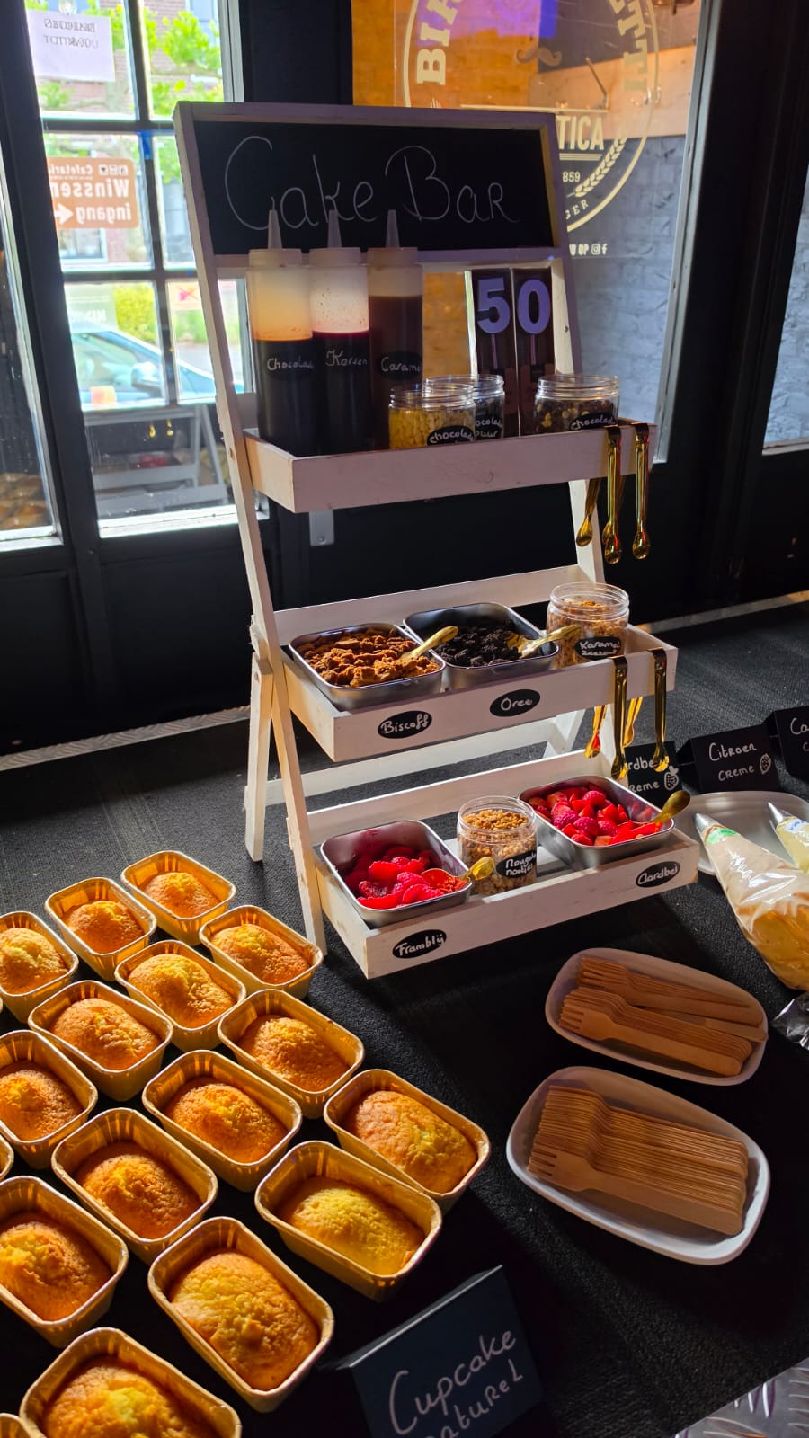 Detail van de cakebar met toppings, fruit en sauzen